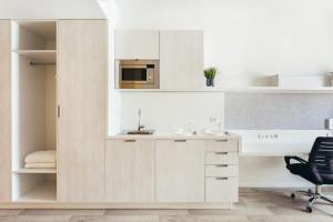a kitchen with white cabinets and a microwave at Soto House Pamplona in Pamplona +37 photos