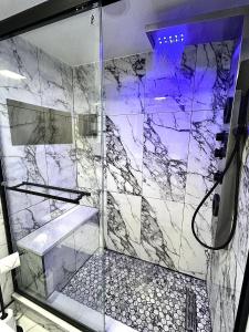 a bathroom with a shower with a marble wall at Theo's Oceanfront Breeze in Myrtle Beach