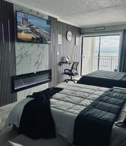 a bedroom with two beds and a flat screen tv at Theo's Oceanfront Breeze in Myrtle Beach