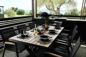 a wooden table with plates and wine glasses on it at MobileHome Serdar in Sveti Filip i Jakov
