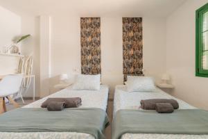 a room with two beds with pillows on them at The Energy Apartment in Caleta De Fuste