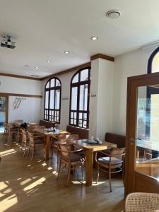 a dining room with tables and chairs and windows at Penzion Luna in Brno