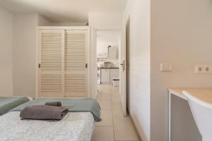 a white room with a bed and a kitchen at The Energy Apartment in Caleta De Fuste