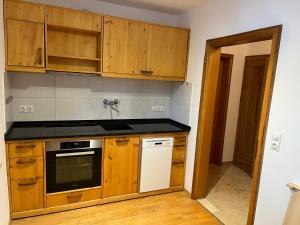 a kitchen with wooden cabinets and a stove top oven at Alpen Apartment "Ruhe & Erholung" in Oberammergau +8 photos