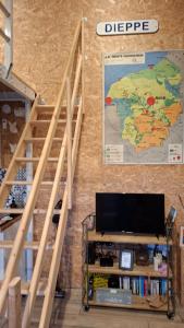a set of stairs with a television and a book shelf at studio indépendant proche de la mer LE Bon Secours in Dieppe