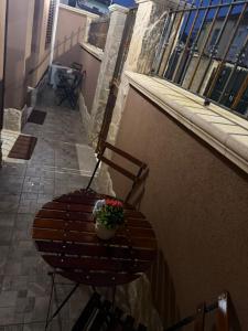 a wooden chair with a flower pot on a balcony at Casa Vacanze Jennifer in Catania