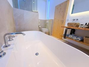 a large white bath tub in a bathroom at Alpenchalet Wasserfallblick in Ramsau +19 photos