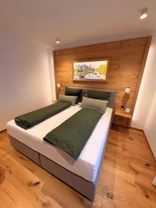 a bedroom with a large bed with a wooden wall at Alpenchalet Wasserfallblick in Ramsau