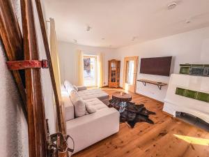 a living room with a couch and a flat screen tv at Alpenchalet Wasserfallblick in Ramsau
