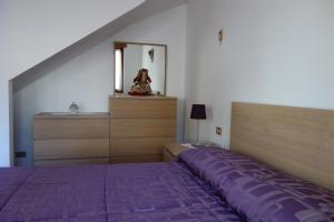 a bedroom with a purple bed and a dresser at Fabbricato Indipendente Centro in Lozzo Cadore