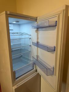 a refrigerator with its door open with its empty shelves at KEY Accommodation Pellicova in Brno