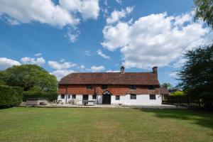 an old brick building with a grass field in front at Gildridge in Lewes