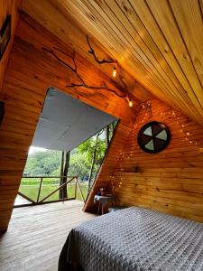 a room with a bed in a wooden cabin at Cabana nas árvores in Mairiporã