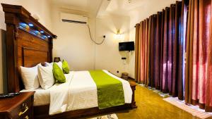a bedroom with a bed and a television and curtains at Ever Breeze Villa Ahangama in Ahangama +72 photos