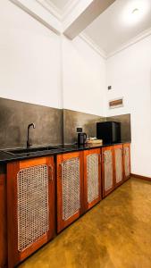 a kitchen with wooden cabinets and a sink in a room at Ever Breeze Villa Ahangama in Ahangama