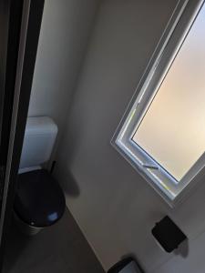 a bathroom with a toilet and a window at Mobile Home Simplicity - Camp Diekirch in Gilsdorf