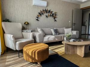 a living room with a couch and two chairs and a table at Chic 2BR City Center Flat in Antalya