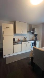 a kitchen with white cabinets and a stove at Escapade en Ardenne - Appartement Sur Jardin Verdoyant in Bertrix