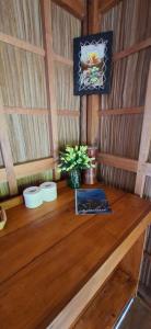 a wooden table with a vase of flowers on it at Yonas Homestay - Raja Ampat in Besir