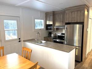 a kitchen with a stainless steel refrigerator and a table at Gîte du Ruisseau in Lamarche