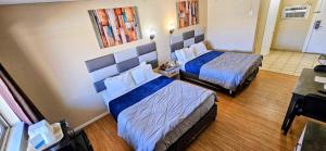 a room with two beds in a hotel room at Rodeway Inn Roswell in Roswell +13 photos