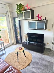 a living room with a tv and a table at Digital Nomad Apartment in L'Escala