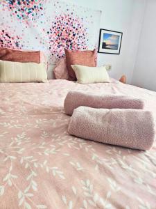 a bed with a pink comforter with balloons on it at Digital Nomad Apartment in L'Escala