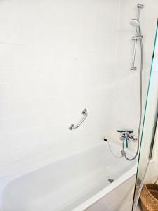 a bathroom with a bath tub with a shower at Digital Nomad Apartment in L'Escala +10 photos