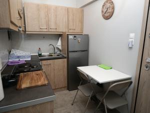 a small kitchen with a sink and a refrigerator at The Nest Apartment in Agioi Theodoroi