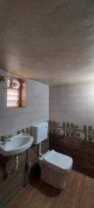 a bathroom with a toilet and a sink at Lucky Homes in Srīvardhan