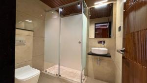 a bathroom with a shower with a toilet and a sink at Hotel Sudha Brahma in Tirupati