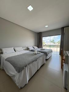 two beds in a bedroom with a large window at Oceane Norte Hotel in Parnaíba