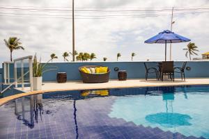 a pool on the roof of a building with an umbrella at Bahia Sol e Mar in Salvador