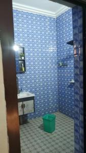 a blue tiled bathroom with a sink and a green bucket at LEYLA house Résidence haut Standing in Bamako +53 photos