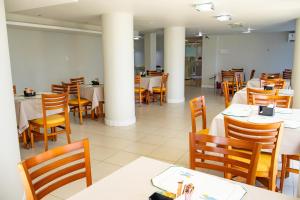 a dining room with tables and chairs and columns at Bahia Sol e Mar in Salvador