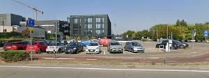 a parking lot with a lot of cars parked at Residence Ki House in Parma