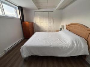 a bedroom with a white bed and a window at Gîte du Ruisseau in Lamarche