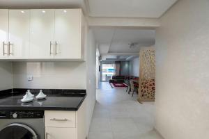 a kitchen with white cabinets and a dishwasher at Apartment in Adan Beach Residence With Pool in Aourir