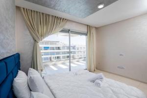 a bedroom with a large bed and a large window at Apartment in Adan Beach Residence With Pool in Aourir +23 photos