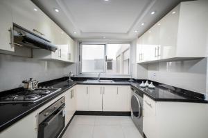 a white kitchen with a sink and a stove at Apartment in Adan Beach Residence With Pool in Aourir