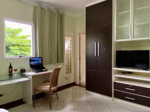 a kitchen with a desk with a laptop on it at Pousada Casa Contos de Minas in Ubatuba