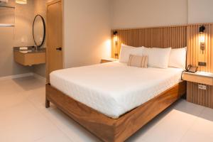 a bedroom with a large bed and a mirror at Hotel Roca Sunzal in La Libertad
