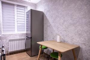 a dining room with a table and a refrigerator at Family Airport in Chişinău