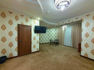 a living room with a tv and a door at DREAM PLAZA HOTEL for your convenience in Bukhara +42 photos