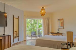 a bedroom with two beds and a large window at Friendly Fun Vallarta Different Experiences - All Inclusive in Puerto Vallarta +49 photos