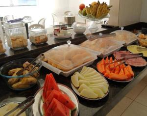a counter with several trays of different types of food at Pousada Terraço das Aguas in Maceió