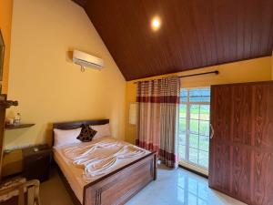 a bedroom with a bed and a large window at Crown Holiday Village near Marawila in Nattandiya