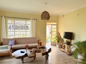 a living room with a couch and a table at Nguruma house of travellers and tours in Arusha