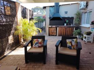 a patio with two chairs and a stove at The Urban Oasis 4 guests Port Elizabeth Gqeberha in Gqeberha