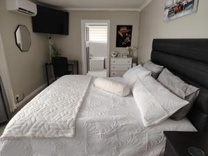 a bedroom with a large white bed with pillows at The Urban Oasis 4 guests Port Elizabeth Gqeberha in Gqeberha